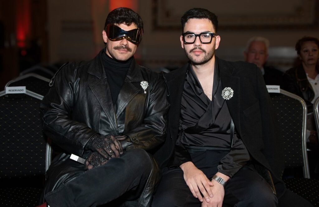 Invitados en primera fila, uno con antifaz negro y chaqueta de cuero – Renato Papiccio Runway, Sofitel Carrasco